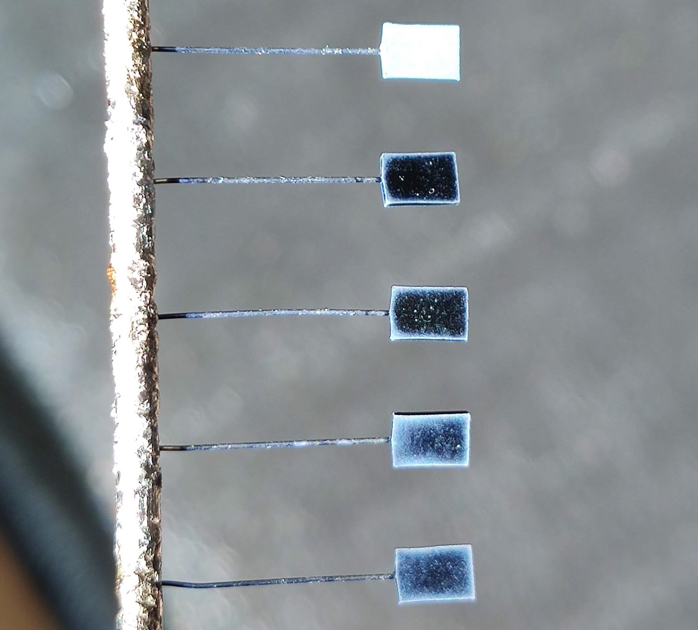 Image showing the appearance of unpackaged tantalum capacitors coated with a film of cathode material based on conductive polymer of various thicknesses